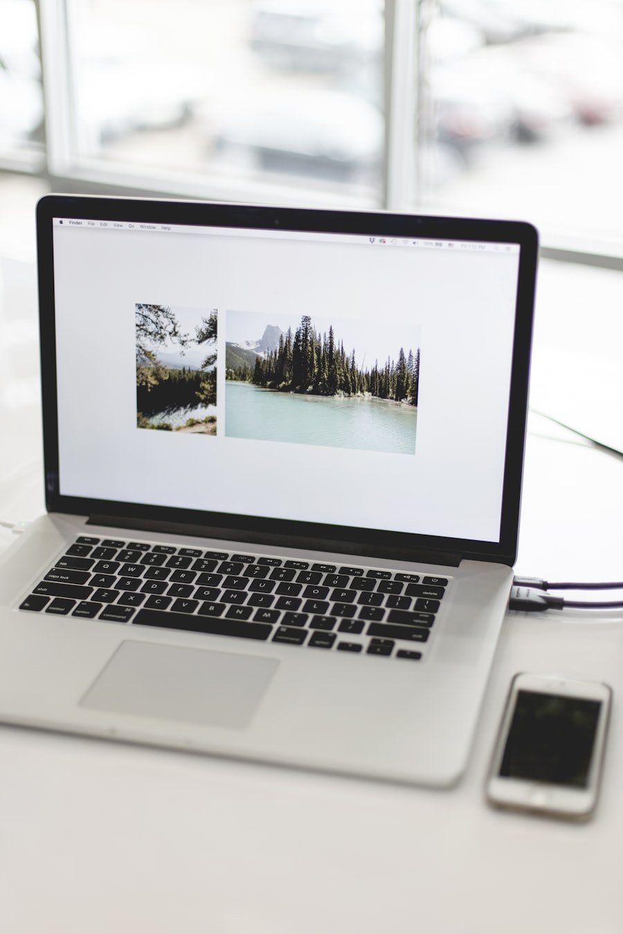 Open laptop by a bright window showing a download in progress